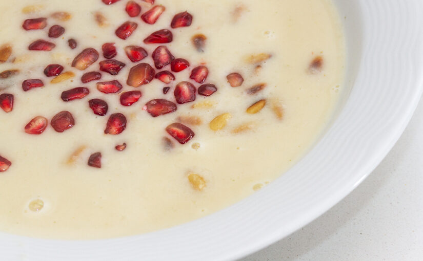 Home made garlic soup with pine nuts and pomegranate seeds